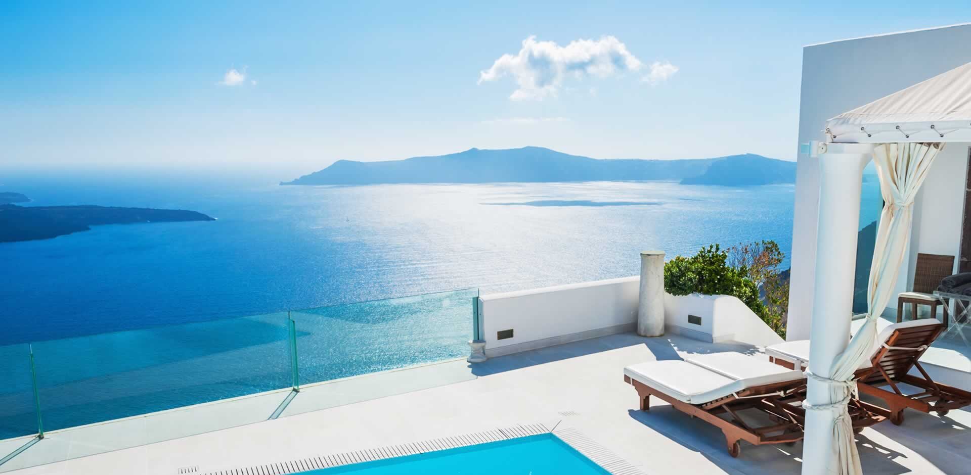 Sun lungers next to a pool overlooking a beautiful ocean view