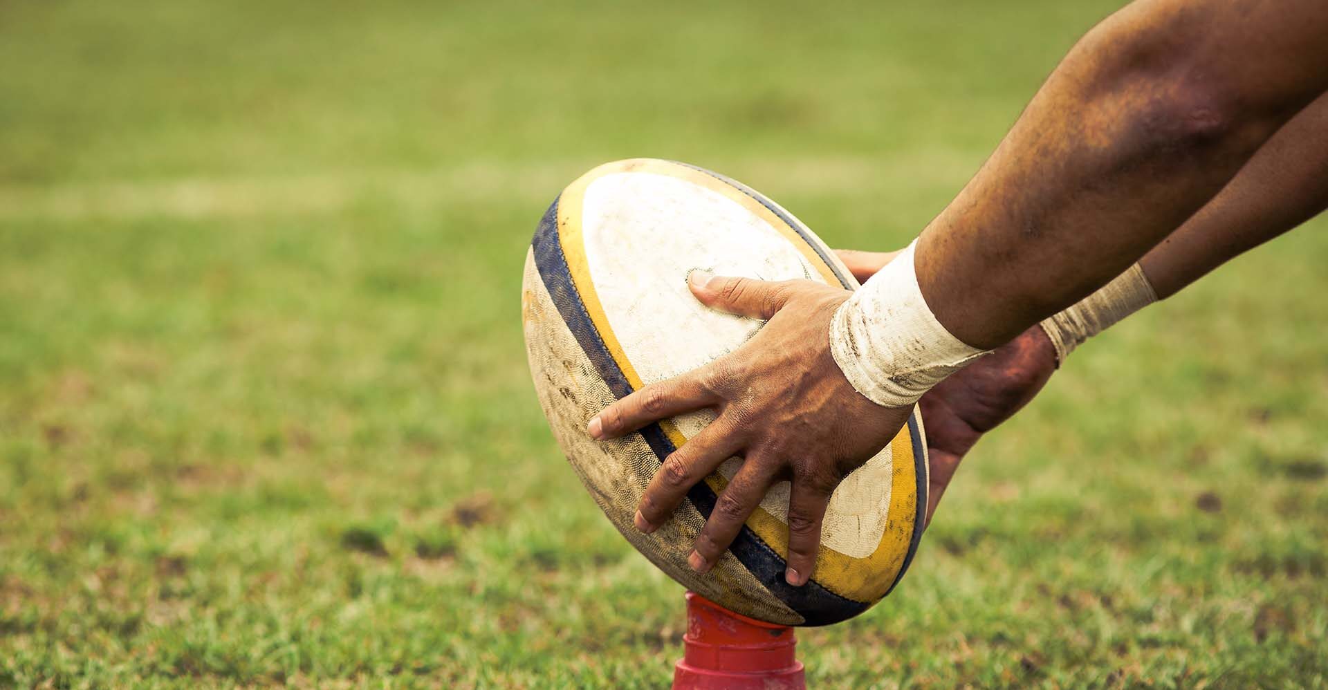 A rugby ball being placed onto a tee
