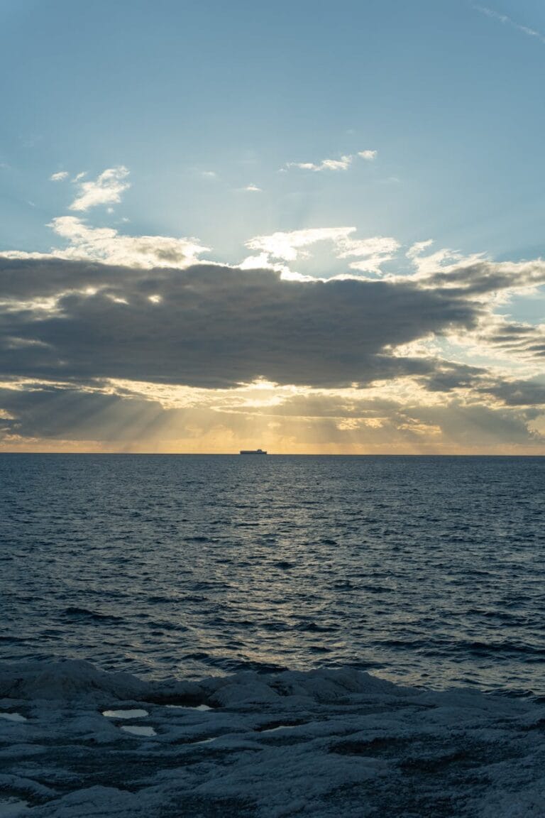 sunset over ocean with distant ship
