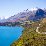 grey road near mountain near body of water photo