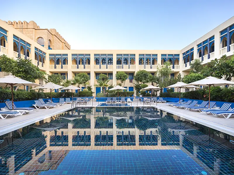 Outdoor swimming pool and Moorish architecture at Medina Diar Lemdina